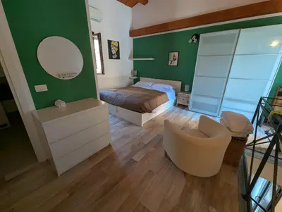 a bedroom with a bed and a mirror and a chair at A casa della Vero in Palermo