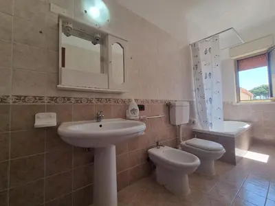 a bathroom with a sink and a toilet and a mirror at House Calamigna in Ventimiglia di Sicilia