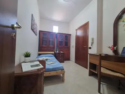 a bedroom with a bed and a desk and a desk at House Calamigna in Ventimiglia di Sicilia
