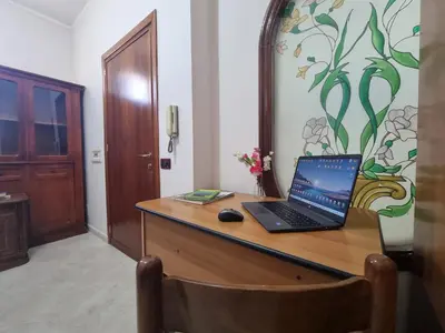 a laptop computer sitting on a wooden desk at House Calamigna in Ventimiglia di Sicilia