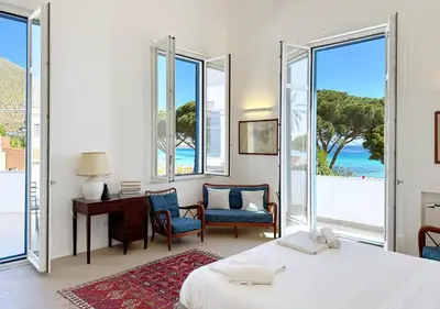 a bedroom with a bed and a desk and windows at Solemar Sicilia - Villa Regina Elena in Palermo