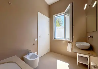 a bathroom with a sink and a toilet and a window at Solemar Sicilia - Villa Regina Elena in Palermo