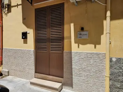 a building with a wooden door on the side of it at The brothers house appartamento alla Zisa in Palermo