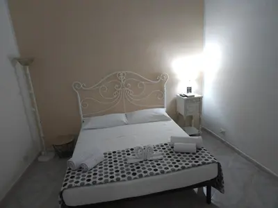 a bedroom with a white bed with a gold headboard at The brothers house appartamento alla Zisa in Palermo
