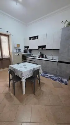 a kitchen with a table in the middle of a room at The brothers house appartamento alla Zisa in Palermo