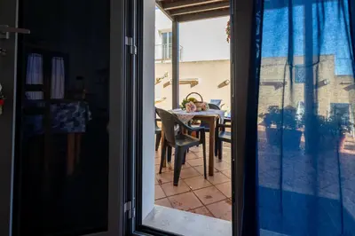 a view of a dining room table from a sliding glass door at Appartamenti da Lulù in San Vito lo Capo