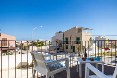 a patio with two chairs and a table on a balcony at Appartamenti da Lulù in San Vito lo Capo