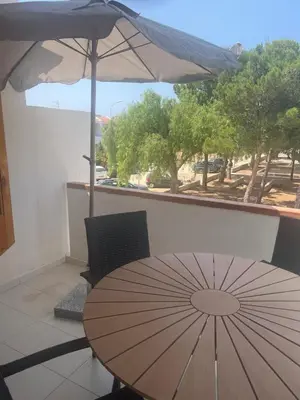 a table with an umbrella on a balcony at cielo blu in San Vito lo Capo