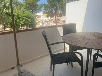 a table and chairs on a balcony with an umbrella at cielo blu in San Vito lo Capo