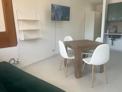a wooden table and white chairs in a kitchen at cielo blu in San Vito lo Capo