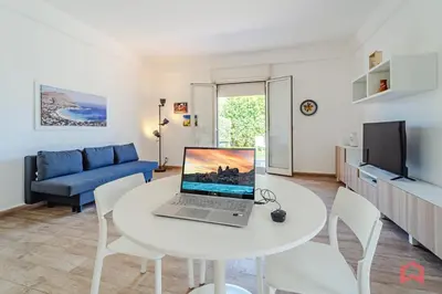 a living room with a white table with a laptop on it at Charming Holiday Home in Palermo in Palermo