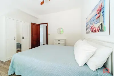 a white bedroom with a bed with white pillows at Charming Holiday Home in Palermo in Palermo