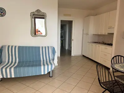 a living room with a couch and a table and a kitchen at Residenza Uliveto in Monreale