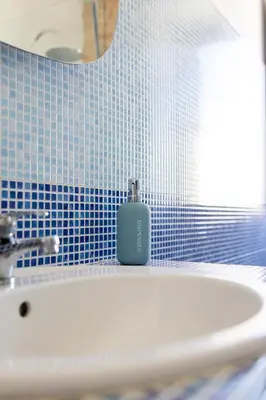 a bathroom with a sink with a soap bottle on it at Appartamento Cinisi in Cinisi