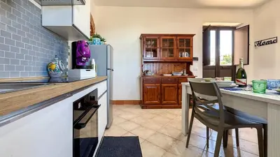 a kitchen with a refrigerator and a table with chairs at Appartamento Cinisi in Cinisi