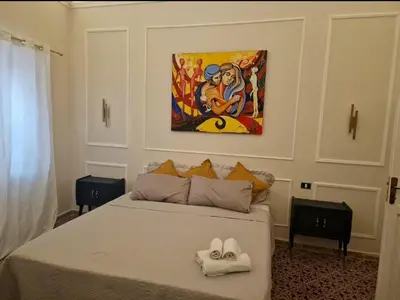 a bedroom with a bed with a painting on the wall at Marea in Palermo