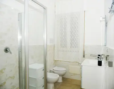 a white bathroom with a toilet and a shower at Brezza Di Mare Palermo in Palermo
