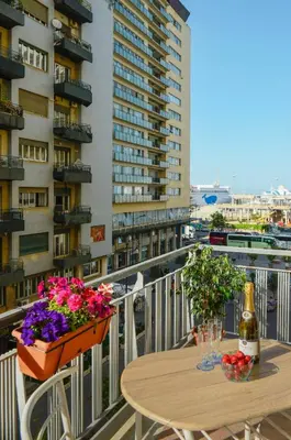 a balcony with a table and flowers and a building at Brezza Di Mare Palermo in Palermo