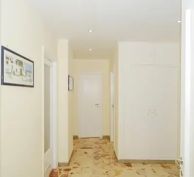 a room with white walls and a hallway with white cabinets at Brezza Di Mare Palermo in Palermo