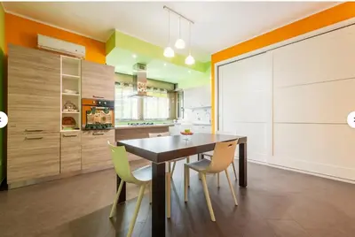 a kitchen with a dining room table and yellow chairs at Guest House Conca D'oro in Palermo