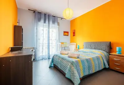 a bedroom with orange walls and a bed and a window at Guest House Conca D'oro in Palermo