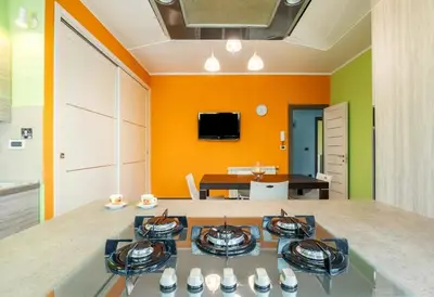 a living room with orange walls and a dining room at Guest House Conca D'oro in Palermo