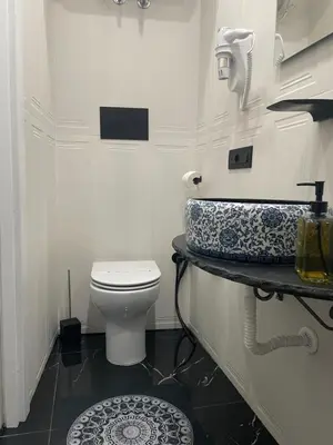 a white bathroom with a toilet and a sink at La Stanza del Viaggiatore in Palermo