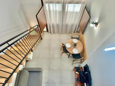 an overhead view of a dining room table and stairs at Loft Pergola, posizione strategica in Castellammare del Golfo