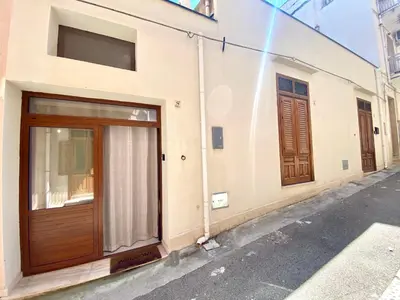 a building with wooden doors on a street at Loft Pergola, posizione strategica in Castellammare del Golfo