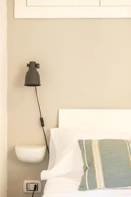 a bedroom with a lamp next to a bed at La suite al Teatro Massimo in Palermo