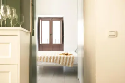 a bedroom with a bed with a window and a table at La suite al Teatro Massimo in Palermo