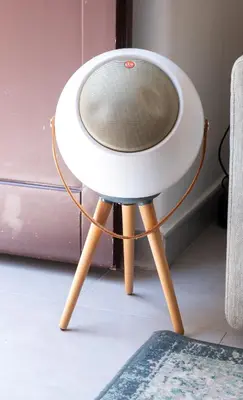 a white speaker sitting on top of a wooden stool at La suite al Teatro Massimo in Palermo