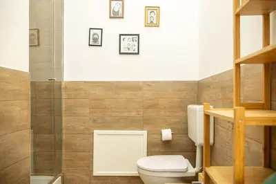 a bathroom with a toilet and some pictures on the wall at La suite al Teatro Massimo in Palermo