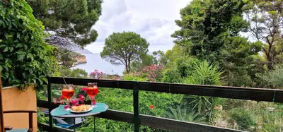 two glasses of wine on a table on a balcony at Villa Dream House Scopello in Scopello