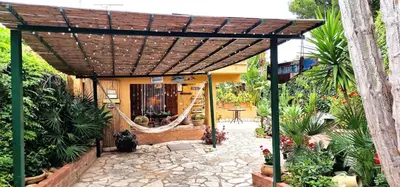 a pergola with a hammock in a garden at Villa Dream House Scopello in Scopello