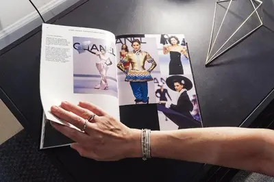 a woman is holding a magazine with photos on it at Loft35 - Loft con Vasca Idromassaggio nel Cuore di Palermo 