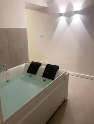 a white bath tub with two black cushions on it at Loft35 - Loft con Vasca Idromassaggio nel Cuore di Palermo 