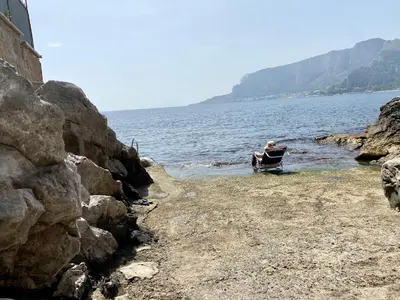 a person sitting in a boat in the water at Charlotte in Palermo