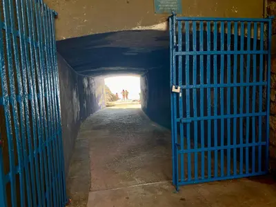 a blue gate in a tunnel with people in the distance at Charlotte in Palermo