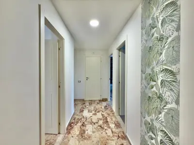a hallway with white walls and a floor with a mural at Cantieri 58 in Palermo