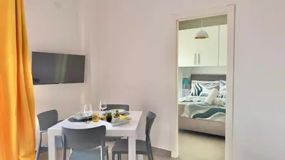 a dining room with a white table and a bed at Cantieri 58 in Palermo