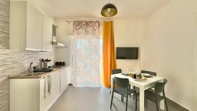 a kitchen with a white table and a table and chairs at Cantieri 58 in Palermo