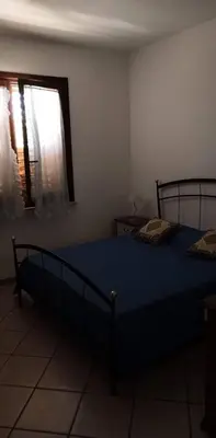 a bedroom with a blue bed and a window at Casa a Campofelice di Roccella in Campofelice di Roccella