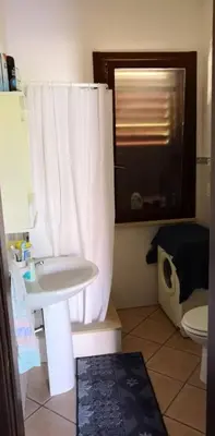 a bathroom with a white shower curtain and a sink at Casa a Campofelice di Roccella in Campofelice di Roccella