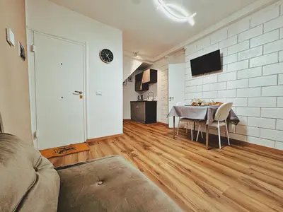 a living room with a table with chairs and a television at Oxalis Rooms & Suite in Palermo