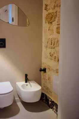 a bathroom with a stone sink on a table at Serafina Suites in Palermo