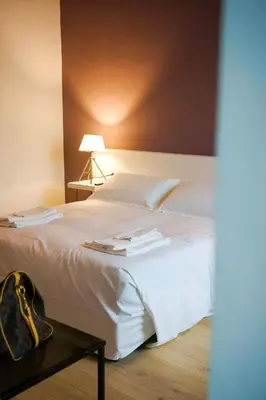 a bedroom with a white bed and a table at Serafina Suites in Palermo