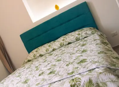 a bed in a bedroom with a green head board at Art suite palermo in Palermo