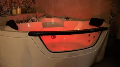 a red bathtub with a red light in a bathroom at Art suite palermo in Palermo