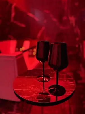 two wine glasses sitting on a red table at Suite Nobile in Palermo